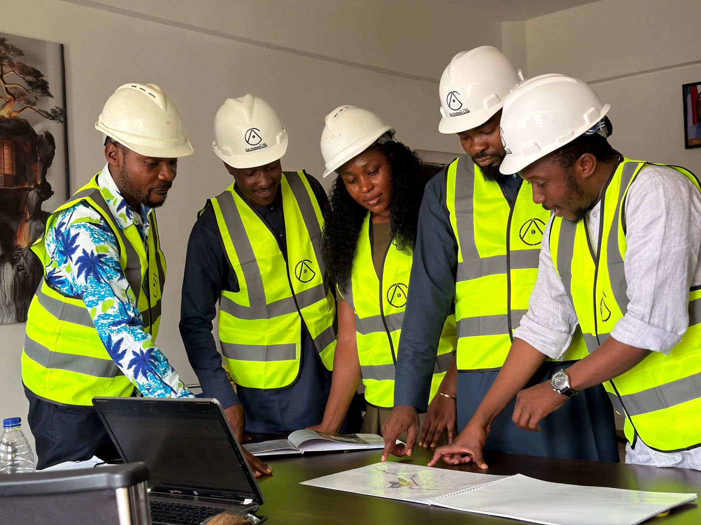 Cinq techniciens en casque préparent un chantier